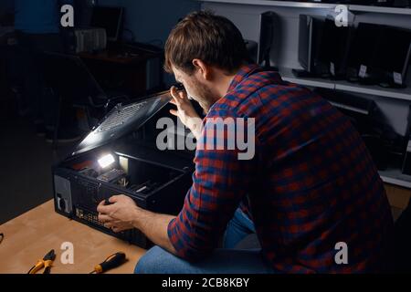 awesome happy man enjoying working with broken computers, favourite job. man has found the reason of broken PC Stock Photo