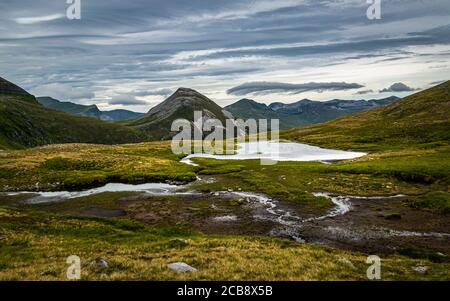 Scottish Highlands landscape. Peak of Binnein Beag seen across the small lochan from the hiking trail in Mamores range, Scotland. Stock Photo