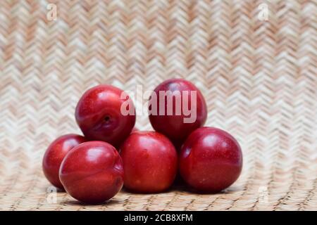 Single plum isolated on white background. Close up of fruit. purple red maroon cherry plum Stock Photo