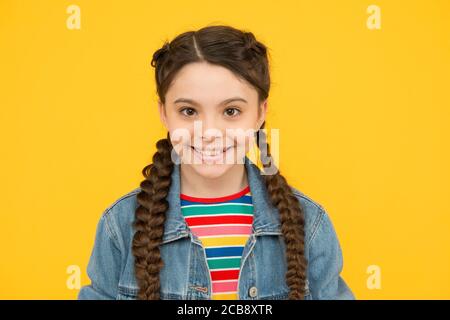 Happy little girl with braids wear denim clothes, fashion trend concept. Stock Photo