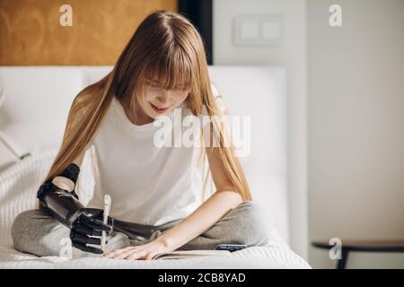 young girl writing a book, disabled girl studing at home. close up photo. copy space Stock Photo