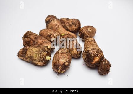 Taro root on white background. Colocasia elephant ear plant root rhizome vegetable also known as Arbi or Arvi