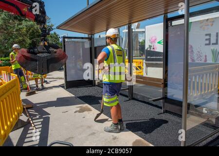 Innsbruck Austria July 27 2020: Workers at work asphalting tram stop with rake and shovel Stock Photo