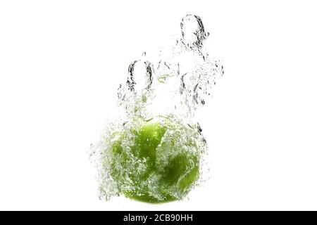 one green apple falling into water on a white background with splashes, drops and bubbles. Stock Photo