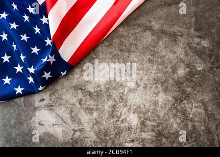 Striking colored American flag isolated in a corner on a stone gray background. Stock Photo