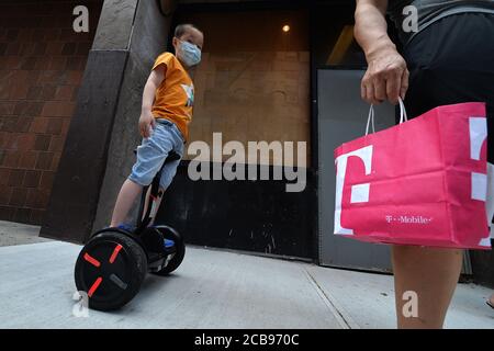New York City, USA. 11th Aug, 2020. A young boy rides a stand up two-wheeled electric scooter along Doyers St. in Manhattan's Chinatown, New York, NY, August 11, 2020. (Anthony Behar/Sipa USA) Credit: Sipa USA/Alamy Live News Stock Photo