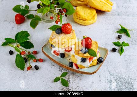 Buttermilk biscuit in plate with berries on white background. Stock Photo