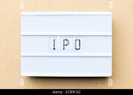 White lightbox with word IPO (Abbreviation of Initial Public Offering) on wood background Stock Photo