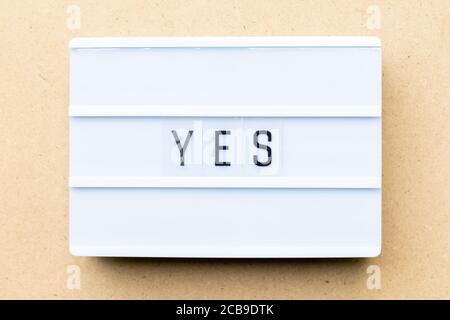 White lightbox with word yes on wood background Stock Photo