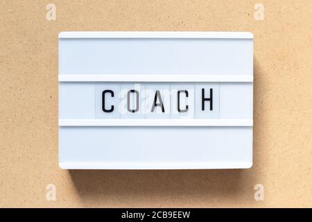 White lightbox with word coach on wood background Stock Photo