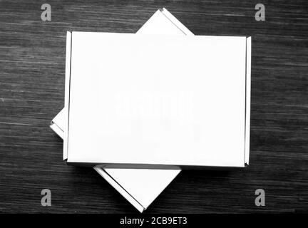 Two white carton boxes isolated on dark wooden background. Top view Stock Photo