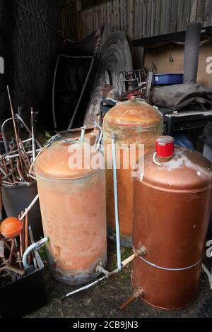Disused hot water cylinders waiting for recycling. Stock Photo