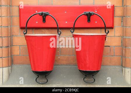 Two Red Vintage Metal Fire Sand Buckets. Stock Photo
