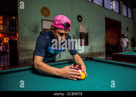 Jinotega / Nicaragua - July 28, 2019: Young Nicaraguan man playing pool in pool hall Stock Photo