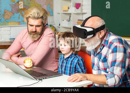 Computer science, Senior teacher wearing virtual reality headset. Father, Grandfather and child son together. Fathers Day. Stock Photo