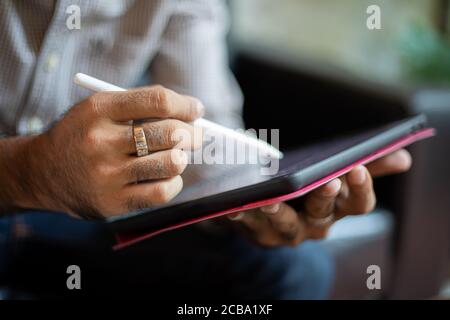 Asian business men using a tablet for working at coffee shop Stock Photo