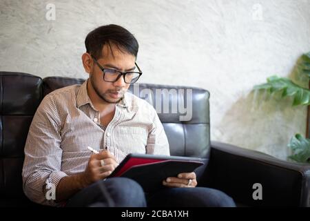 Asian business men using a tablet for working at coffee shop Stock Photo