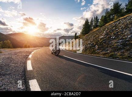 Motorcycle driver riding in Alpine road, Austria, Europe. Outdoor photography, mountain landscape. Travel and sport photography. Speed and freedom con Stock Photo