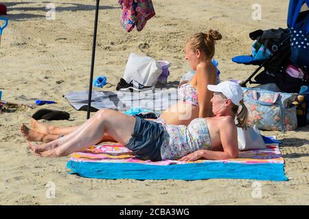 Lyme Regis, Dorset, UK.  12th August 2020.  UK Weather.  Sunbathers on the beach at the seaside resort of Lyme Regis in Dorset on another scorching hot sunny day as the heatwave continues.  Picture Credit: Graham Hunt/Alamy Live News Stock Photo