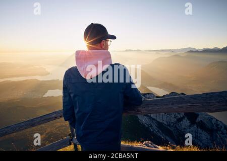 Hiker looking at mountain range at sunrise. View from Mount Pilatus, Lucerne, Switzerland Stock Photo