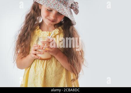 Beautiful little girl with spoon in mouth eating tasty cream. Eating yummy ice cream is fun Stock Photo