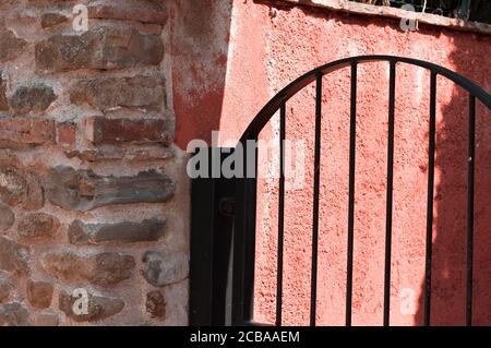 Gratings of a black metallic gate of a brick house (Pesaro, Italy, Europe) Stock Photo