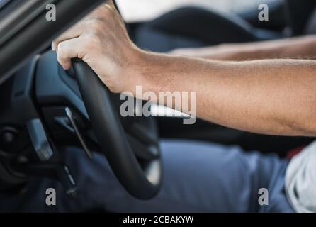 Caucasian Drivers Hands on the Car Steering Wheel Close Up. Automotive Industry Theme. Stock Photo