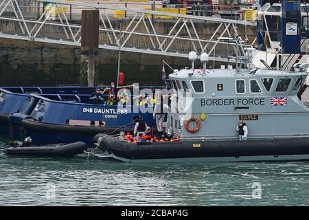 A group of people thought to be migrants are brought into Dover, Kent, by Border Force officers following a number of small boat incidents in the Channel earlier today. Stock Photo