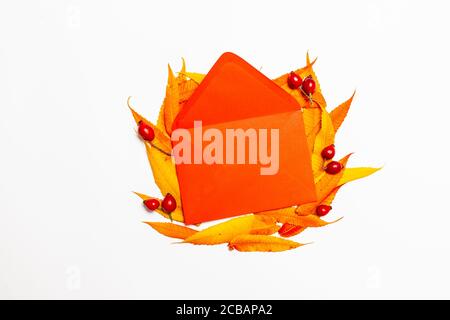 Top view of opened red paper envelope with yellow red leaves. Creative flat lay composition, above. Summer, autumn greeting card Stock Photo