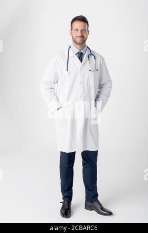 Full length shot of smiling male doctor standing at isolated white background with copy space. Stock Photo