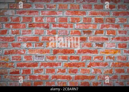 Renovated old red brick wall texture with vignette. Weathered, grungy red brick wall with peeling old white paint. Stock Photo