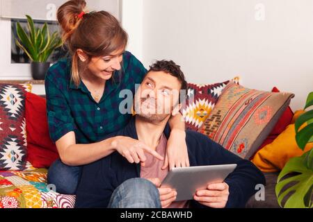 cheerful happy couple at home using tablet Stock Photo