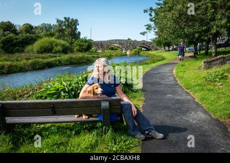 A dog walker on the path beside the River Ythan in the town of Ellon in Aberdeenshire, Scotland, UK Stock Photo