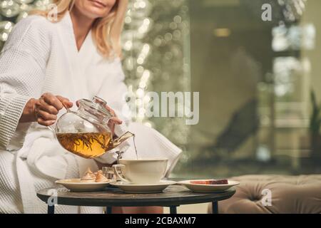 Female pouring green tea in a cup at the breakfast Stock Photo