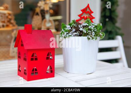 Red house made by paper , Christmas decor . Restaurant white table decorated for holiday Stock Photo