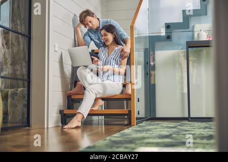 Laughing cheerful lady with man are using modern computer Stock Photo