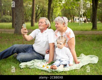 Grandparent with grandson using tablet for video call with family Stock Photo