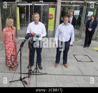 Garda Colm Donohoe, the brother of Adrian Donohoe, speaks to the press, with Caroline Donohoe (back right), the widow of Adrian Donohoe outside the Criminal Courts of Justice, Dublin, where the jury agreed 11-1 in favour of the guilty verdict after 22 hours of deliberation in the Aaron Brady trial for the capital murder of Detective Garda Adrian Donohoe, who was shot dead during a robbery at Lordship Credit Union near Dundalk in January 2013. Stock Photo