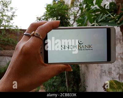 DISTRICT KATNI, INDIA - JUNE 02, 2020: An indian woman holding smart phone with displaying Sindh Bank Limited logo on screen, modern Pakistani schedul Stock Photo