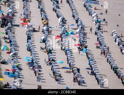 12 August 2020, Mecklenburg-Western Pomerania, Rostock: Bathers at the beach in Warnemünde. In summer temperatures and sunshine, holidaymakers and residents are attracted to the beaches along the Baltic Sea. Photo: Jens Büttner/dpa-Zentralbild/dpa Stock Photo