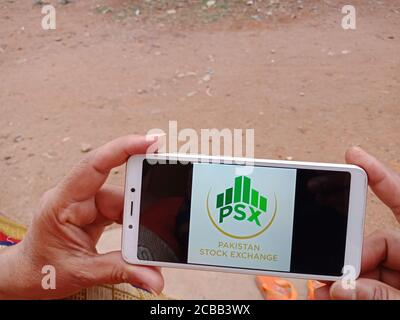 DISTRICT KATNI, INDIA - JUNE 02, 2020: An indian woman holding smart phone with displaying Pakistan Stock Exchange logo on screen, modern banking educ Stock Photo