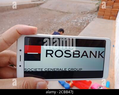 DISTRICT KATNI, INDIA - JUNE 02, 2020: An indian woman holding smart phone with displaying Rosbank Business bank logo on screen, modern banking educat Stock Photo