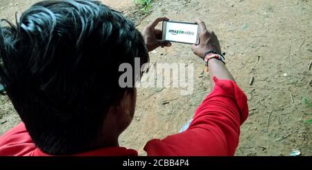 DISTRICT KATNI, INDIA - SEPTEMBER 18, 2019: Amazon Prime Video logo displayed on smart phone screen by indian village man hand holding mobile concept. Stock Photo