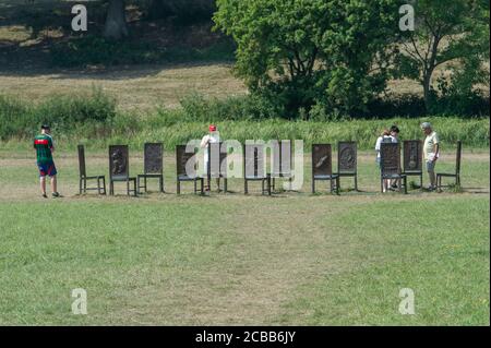 Egham, Surrey, UK. 12th August, 2020. People enjoy their walk in hot heatwave sunshine in the countryside at the National Trust land at Egham as they look at the Jurors sculpture by Hew Locke. It is described by the NT as 'an artwork exploring the ongoing significance of Magna Carta'. Credit: Maureen McLean/Alamy Live News Stock Photo