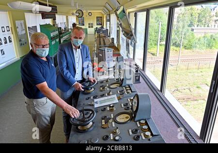 12 August 2020, Saxony, Chemnitz: Wolfgang Vogel (l) from the Verein Eisenbahnfreunde Richard Hartmann, guides Thomas Schmidt (CDU), Minister for Regional Development in Saxony, through the signal box on the premises of the 'Schauplatz-Eisenbahn'. The signal box is one of the more than 100,000 monuments that the Free State of Saxony counts and thus has the highest density of monuments nationwide. Over the past 30 years, Saxony has invested more than 3.6 billion euros in the protection of historical monuments. According to the state government, this treasure must be preserved, but also used sen Stock Photo