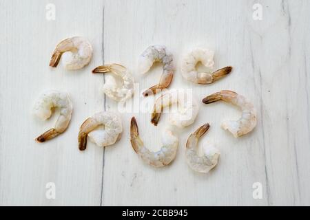 Peeled fresh raw white prawns on wooden background Stock Photo