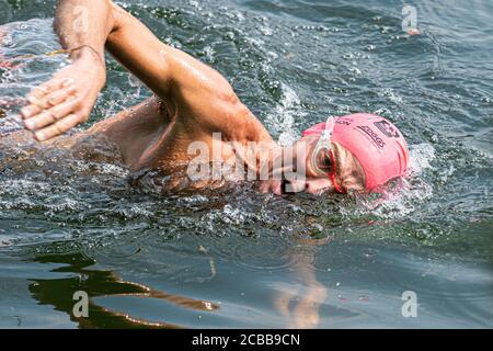 KINGSTON LONDON, UK - 12 August 2020.  A man swimming in the River Thames to cool off from the heat and humidity on another sweltering day in London as heatwave conditions continue.  The forecast is for high temperatures to remain until Thursday with thunderstorm warnings in place. Credit: amer ghazzal/Alamy Live News Stock Photo