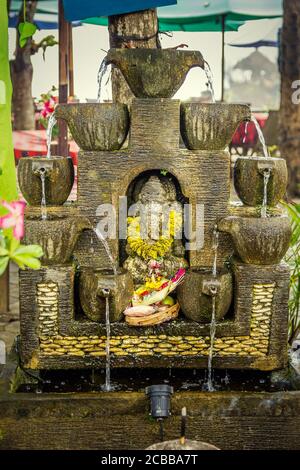 Statue and Balinese offering in Bali, Indonesia Stock Photo