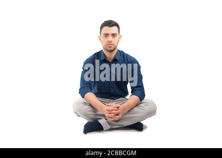 Italian Brazilian young man sitting on infinite pure white background Stock Photo