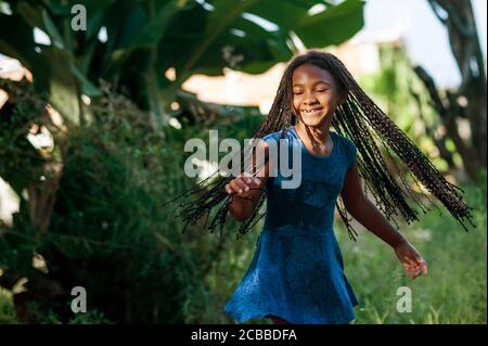 Young african girl playing and dancing in the nature